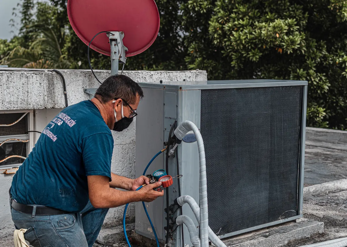 HVAC technician checking refrigerant pressure with manifold gauges — part of Sacramento HERS evaluation